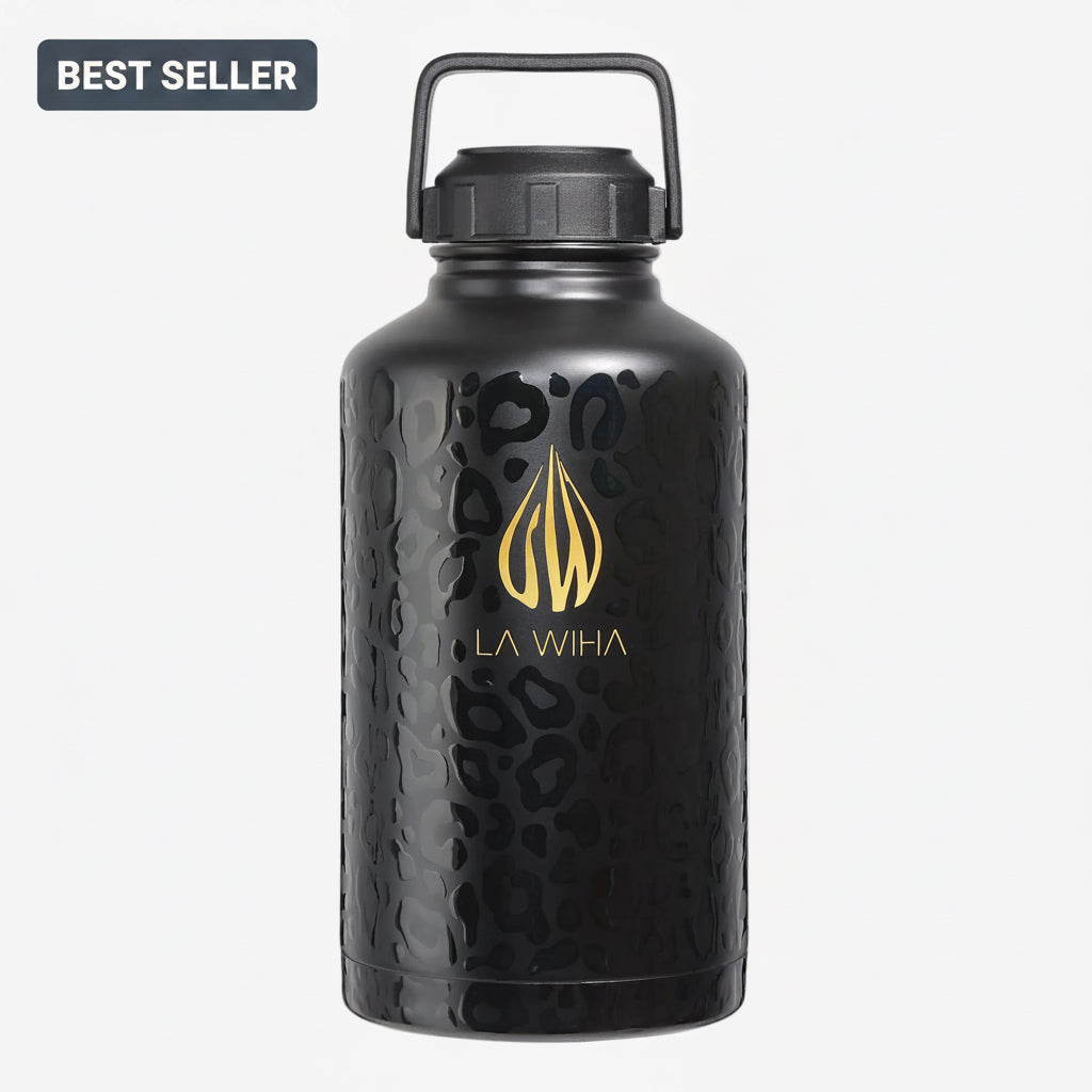 A matte black textured leopard print insulated 64oz Stainless Steel Water Bottle With Handle Lid featuring a gold La Wiha logo and name on the front, complete with a black carrying loop lid, set against a plain white background. Stay hydrated with our 64oz black leopard insulated stainless steel bottle, featuring a handle lid for easy carry. Ideal for adventurers and fitness enthusiasts, it maintains beverages hot or cold for hours. A must for active lifestyles.