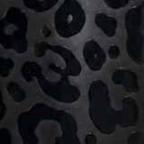 A close-up of a glossy 3D printed black leopard print pattern on a dark black background.